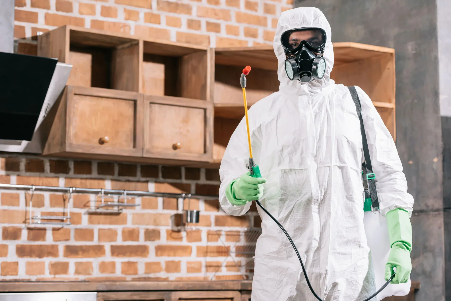 Pest control technician with sprayer preparing fumigation treatment